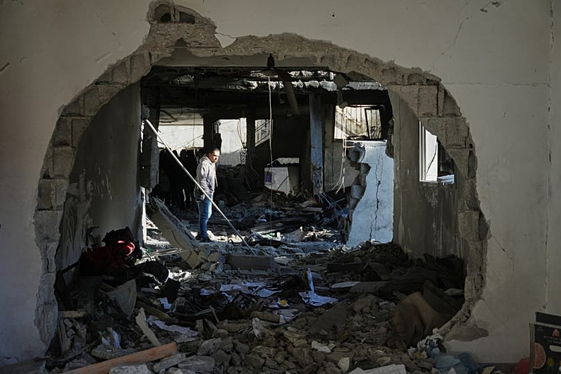 Bir Filistinli, Gazze Şeridi'ndeki bir enkaza bakıyor.